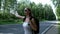 Hitchhiking woman with backpack standing on road