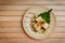 Hiyayakko Japanese tofu. Japanese cold tofu with soy sauce, green onion, bonito flakes and oba leaf in a ceramic bowl.