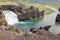 Hjalparfoss waterfall in Iceland with azure water viewed from the top of a hill