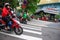 Ho Chi Minh city, Vietnam - December 2018: woman on motorbike crossing crosswalk near Saigon Skydeck.