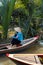 Ho Chi Minh City, Vietnam- November 9, 2022:Woman with conical Vietnamese hat controls a canoe. Tourism rowing boat in the Mekong