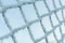 Hoarfrost on steel wire mesh in winter against blue sky