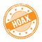 HOAX text written on orange grungy round stamp