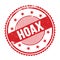 HOAX text written on red grungy round stamp