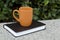 Hobbies reading and coffee - orange mug and black book sitting on a ledge.