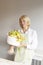 Hobby and activity:white Caucasian female florist looks and holds on skewers ready edible fruits arrangement gift bouquet