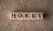 HOBBY word written on wooden blocks on a brown background