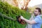 Hobbyist gardner using an hedge clipper in the home garden