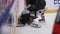 Hockey player pushes opponent fighting for puck on ice arena