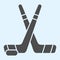 Hockey sticks solid icon. Field crossed game inventory and puck. Sport vector design concept, glyph style pictogram on