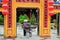 Hoi An / Vietnam, 11/11/2017: Local Vietnamese woman with rice hat and bicycle entering a yellow assembly hall in Hoi An in