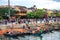 Hoi An, Vietnam - 27 Jul 2019: Historical town riverside with yellow buildings and tourists. People crowd on embankment