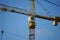 Hoisting construction crane on a background of blue sky.