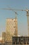 Hoisting crane and new multi-storey building. ndustrial background. Construction of high-rise houses and hoisting tower