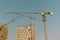 Hoisting crane and new multi-storey building. ndustrial background. Construction of high-rise houses and hoisting tower cranes. Ne
