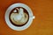 Hojicha latte with milk foam art on wooden background