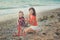 Hokum tender scene of beautiful adorable young mother enjoy life time summer vacation with her little baby girl daughter on sand b