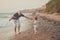 Hokum tender scene of handsome bolt happy father enjoy life time summer vacation with his little baby girl daughter on sand beach.