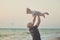 Hokum tender scene of handsome bolt happy father enjoy life time summer vacation with his little baby girl daughter on sand beach.
