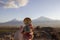 holding a compass against the backdrop of Mount Ararat at sunset