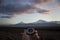 holding a compass against the backdrop of Mount Ararat at sunset