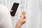 Holding crypto coin and mobile phone on white background