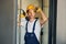 Holding electric drill in hands. Young man working in uniform at construction at daytime