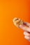 Holding a fried snack chicken nuggets on an orange background in your hand