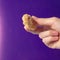 Holding a fried snack chicken nuggets on an purple background in your hand