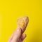 Holding a fried snack chicken nuggets on an yellow background in your hand