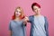 Holding hands of two lesbian girls. On a pink background.