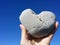 Holding heart rock on the blue sky