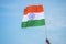 Holding indian tricolor flag on blue sky