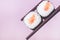Holding a Maki Sushi Piece with Chopsticks onPink Background Culinary Gourmet Japanese Food Close Up
