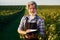 Holding notepad. Senior stylish man with grey hair and beard on the agricultural field with harvest