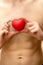 Holding a red heart against a bare male torso