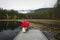 Holding red umbrella on a dock