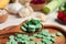 Holding spoon of prebiotic pills near table with food, closeup