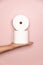 Holding two Toilet rolls with pink background