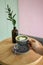 Holding up matcha green tea latte heart shaped art in a grey cup on a brown table with pastel background