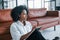 Holds notepad. Young african american woman with curly hair indoors at home