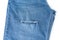 Hole in blue jeans fixed with safety pins