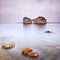 Hole island and rocks in a tropical blue ocean. Cloudy sky.