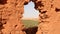 A hole in a mud wall overlooking the palm oasis