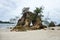 A hole on a small quartzite mountain on the sandy beach. Pierced stone Khao Hin Thalu or hole in a massive rocky cliff