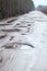 Holes and puddles on bad broken road in woods