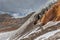 Holes in the very steep ice of the Vallelunga glacier above red rocks