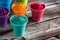 Holi colored powder in cups on the wooden table dark. Holi color festival. Selective focus