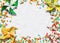 Holiday background with colorful confetti and homemade paper fans, light background, top view. Free space for text