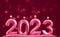 Holiday background Happy New Year. Numbers 2023 made by viva magenta candles. Minimalistic horizontal pink background